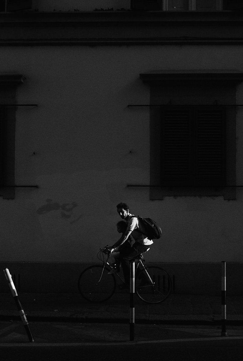 street photos of father and daughter riding bicycle in florence italy